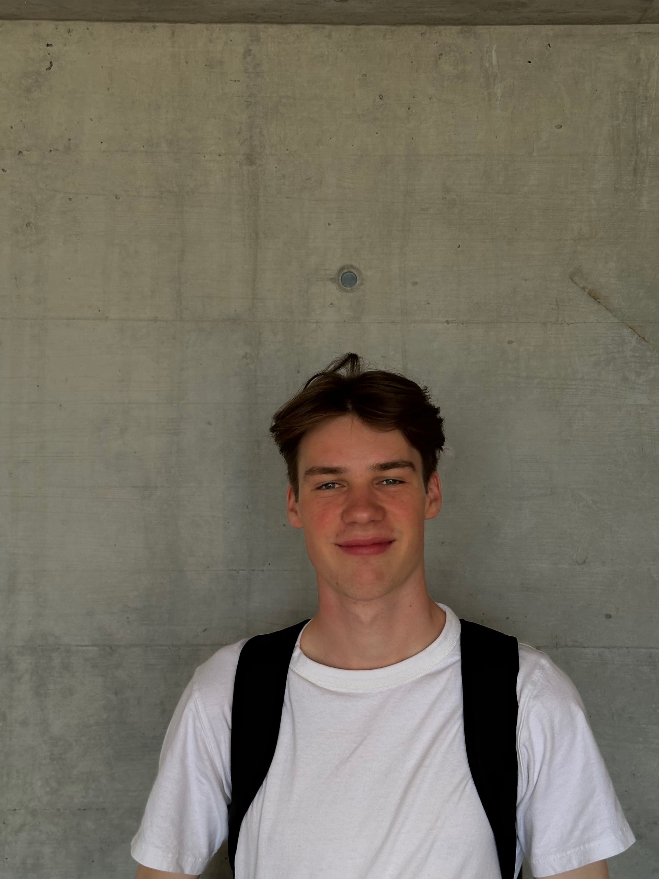Anton standing in front of a concrete wall