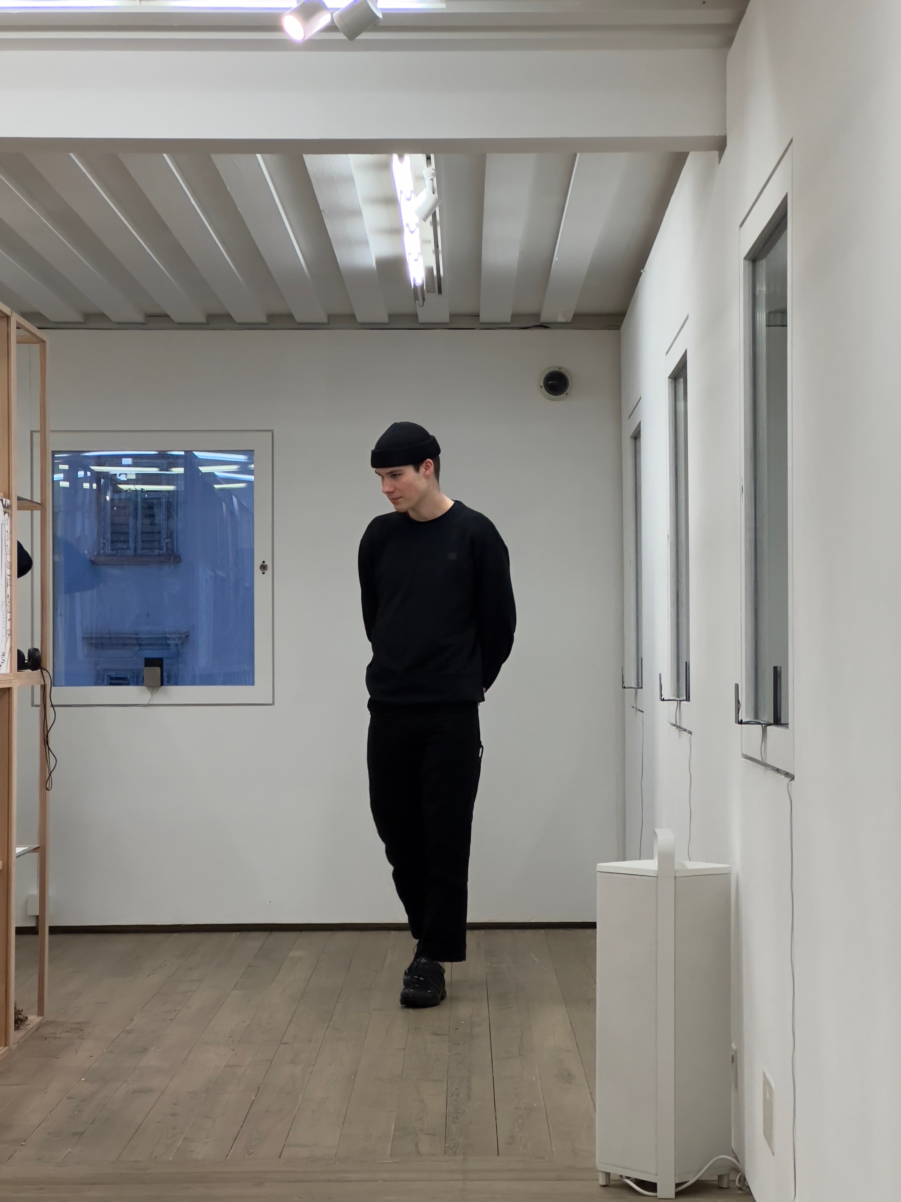 Anton looking at a object in a white room