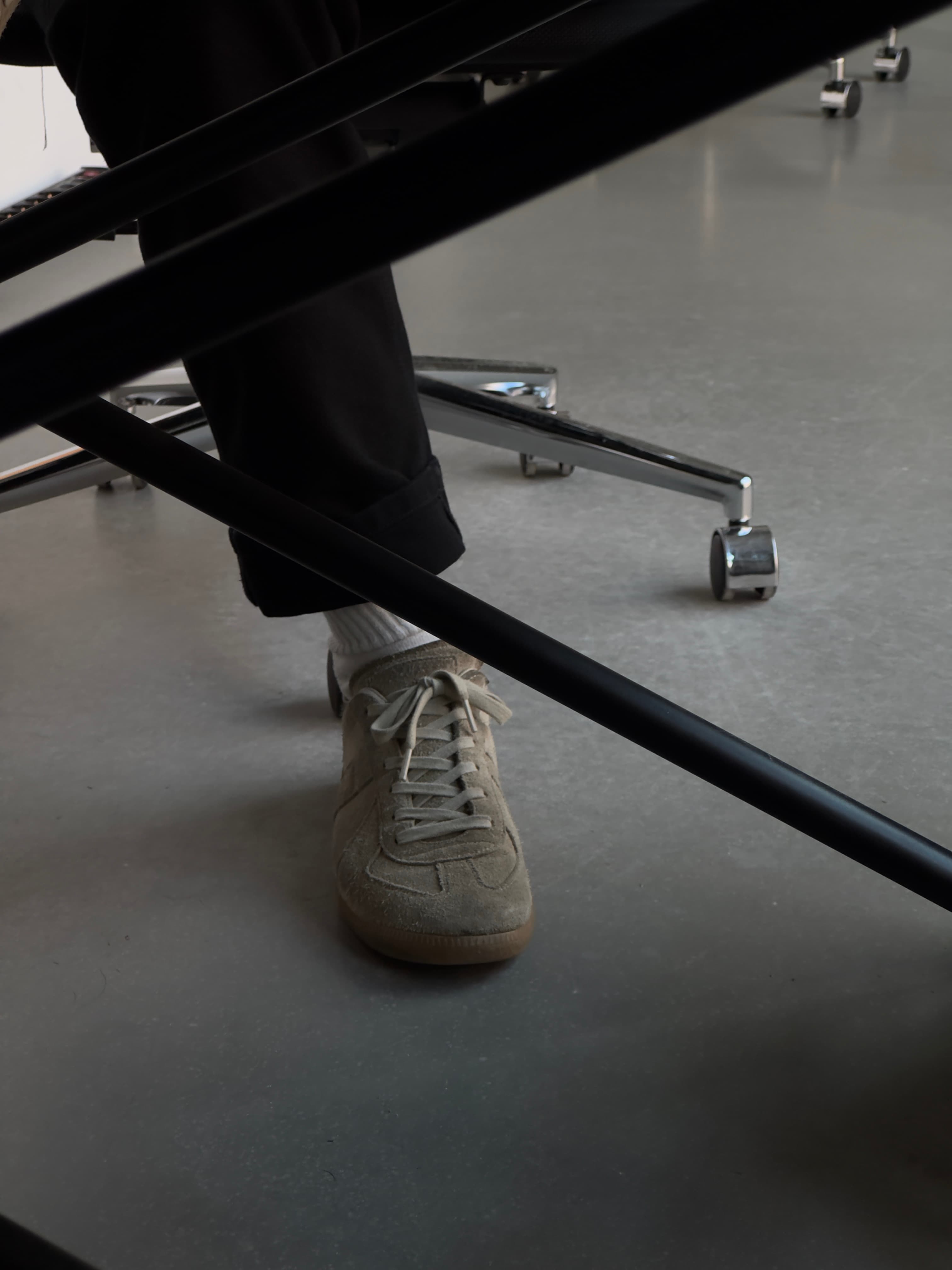 A persons shoe under a desk