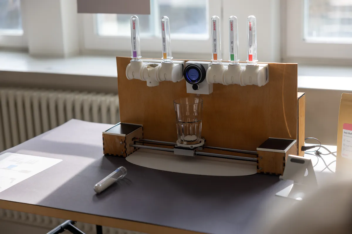 A dispenser with various nutritions and a glass of water on a sliding tray